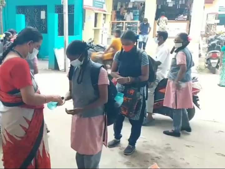 பள்ளிக்குள் செல்வதற்கு முன், உடல் வெப்ப அளவை சோதிப்பதற்காக வரிசையில் காத்திருக்கும் மாணவிகள்.