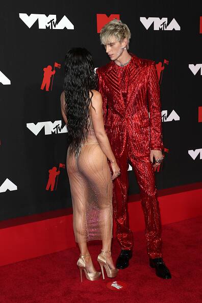 31-year-old Machine Gun Kelly looked sharp in a shimmery red Dolce & Gabbana suit with jewels on his face. [pic credit: Gettyimages]