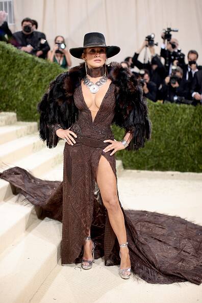 Jennifer Lopez wowed in a plunging brown embroidered gown with a faux fur shearling coat and a hat; she is in custom Ralph Lauren. [pic credit: Gettyimages]
