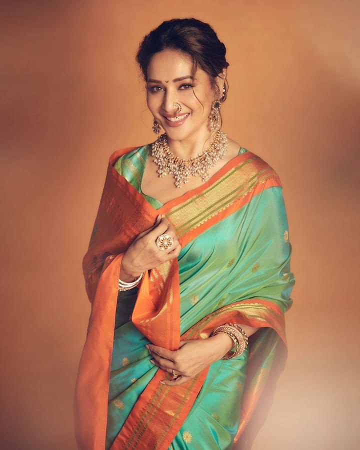 माधुरी दीक्षित इस लुक में काफी स्टाइलिश लग रही हैं. उन्होंने इस साड़ी के साथ टियरड्रॉप इयररिंग्स कैरी किए हुए हैं. अदाकारा हर तरह की ड्रेस में अपनी चमक बिखेरती हैं. माधुरी दीक्षित को साड़ी पहनना काफी पसंद है. रीयल लाइफ में उनके पास साड़ी का काफी अच्छा कलेक्शन है.