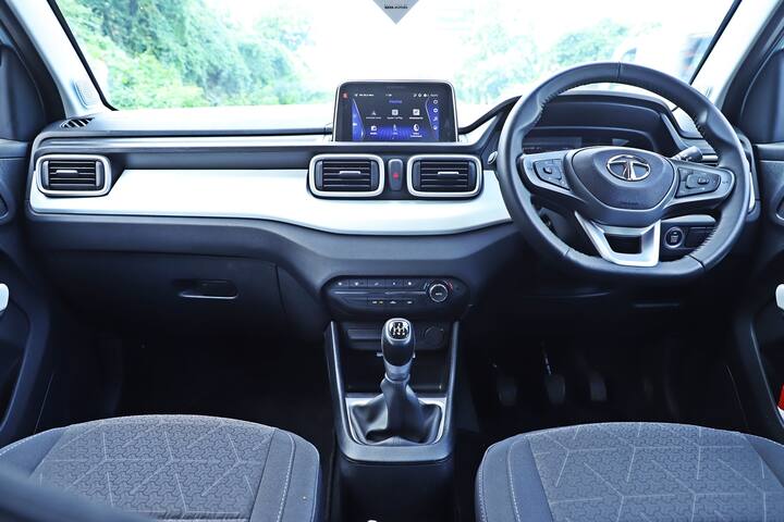 ट्रैफिक लाइट पर मेरे पास केबिन की जांच करने के लिए बहुत समय था. इंटीरियर में टाटा की अन्य कारों के समान स्टीयरिंग व्हील और पार्ट डिजिटल इंस्ट्रूमेंट्स हैं, लेकिन मुझे व्हाइट मिडिल लेयर से लेकर डैश तक ट्राई-एरो मार्किंग के साथ-साथ एयर वेंट डिज़ाइन पसंद है. यह अलग दिखता है. क्वालिटी भी डिसेंट है. पीछे की तरफ फ्लैट फ्लोर के साथ स्पेस बिट अधिक प्रभावशाली है जिससे तीन पैसेंजर्स की संभावना मिलती है और यह वास्तव में बड़ी सबकॉम्पैक्ट एसयूवी की तुलना में अधिक विशाल है. चौड़े खुलने वाले दरवाजे भी अंदर और बाहर आना आसान बनाते हैं.