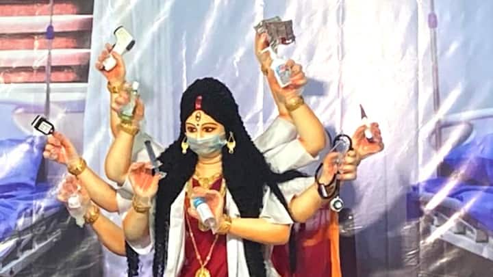 দেবী প্রতিমার গায়ে রয়েছে চিকিৎসকদের অ্যাপ্রন, হাতে রয়েছে অক্সিমিটার, স্যানিটাইজার, ওষুধের স্ট্রিপ, স্টেথস্কোপ ও অন্যান্য চিকিৎসার সামগ্রী।