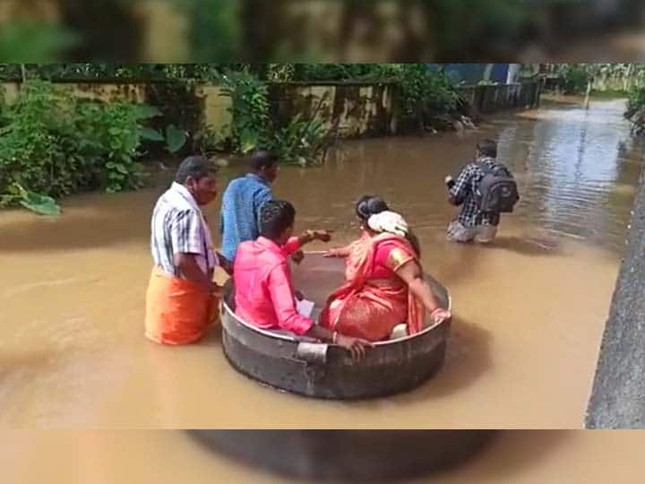 Kerala Floods Viral Video bride groom arrives wedding hall sitting in cooking vessel for marriage Kerala Floods Viral Video : केरळात पुराचा हाहाःकार; जोडपं स्वयंपाकाच्या भांड्यातून लग्नस्थळी,  व्हिडीओ व्हायरल