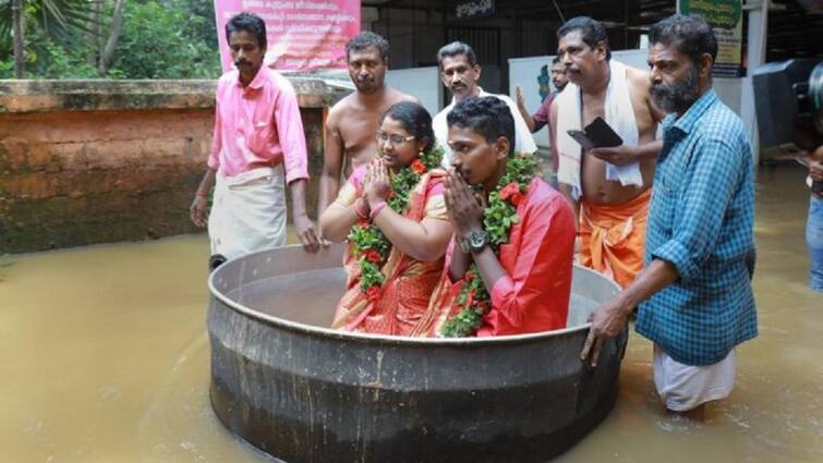 A unique wedding took place between heavy rains and floods in Kerala, the bride and groom reached the wedding venue sitting in the escapade કેરળમાં ભારે વરસાદની વચ્ચે અનોખા લગ્ન, મોટા વાસણમાં બેસીને લગ્મ મંડપ સુધી પહોંચ્યા નવ દંપતિ