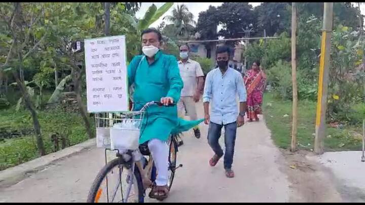 স্বপন দেবনাথ তাঁর সাইকেলের সামনে লাগিয়েছেন প্ল্যাকার্ড।