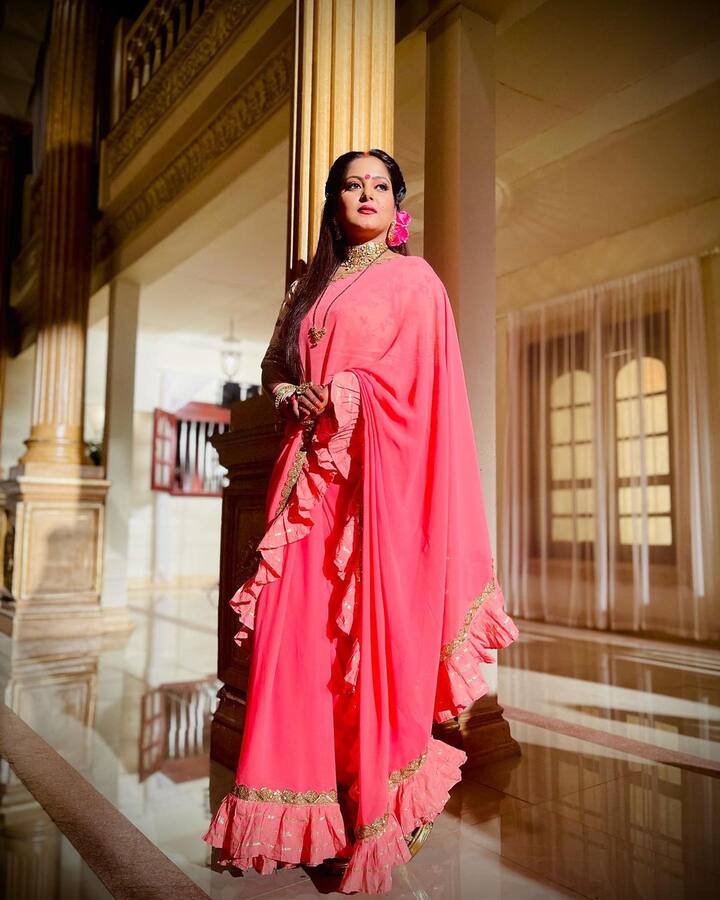 अंजना सिंह की तरह फ्रिल लगे पल्लू वाली इस पिंक साड़ी का सेलेक्शन भी कर सकती हैं. बालों में फूल लगाकर आप फेस्टिवल के लिए रेडी हो सकती हैं. साथ में चोकर पहनें तो और सुंदर दिखेंगी.