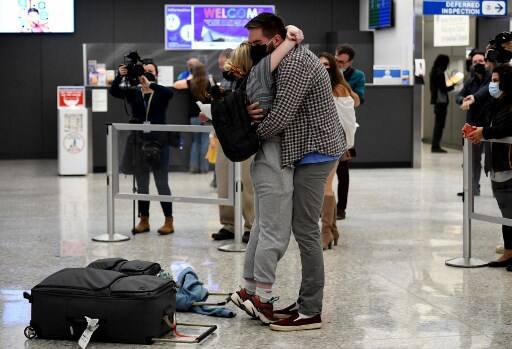 A young couple hugs each other as one of the partners travelled from Germany to US. Courtesy: AFP