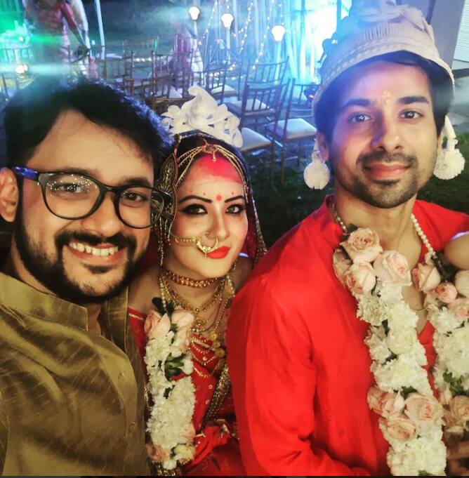 Newlyweds posing with guest.