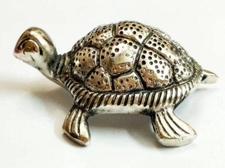 धातु का कछुआ- हर कोई नए साल की शुभ शुरुआत करना चाहते हैं.ऐसे में कुछ चीजों का ध्यान रखकर आप घर पर मां लक्ष्मी की कृपा बनाए रख सकते हैं. वास्तु के अनुसार घर में धातु का कछुआ रखना शुभ  माना जाता है. घर में इसे रखने से खुशहाली और समृद्धि का विकास होता है. नए साल पर आप घर में पीतल, कांसे या चांदी से बने कछुए की मूर्ति रख सकते हैं. इससे आपकी किस्मत बदल सकती है.