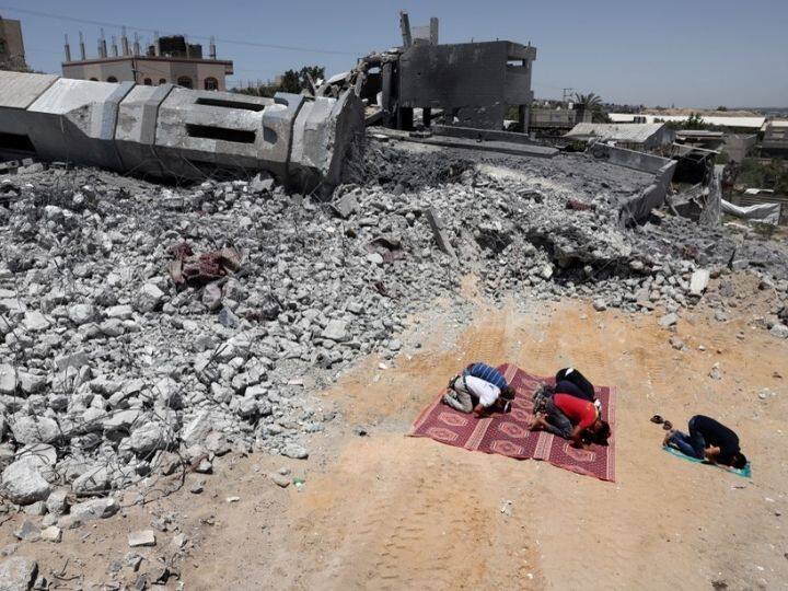 Palestinian Muslim worshippers pray near the rubble of a destroyed mosque in Beit Lahia, in the northern Gaza Strip, on May 27, 2021. After 11 days of deadly violence between Israel and the Hamas movement, which runs Gaza, a ceasefire was reached. According to the Gaza health ministry, bombardment by Israel killed 248 Palestinians, including 66 children, while Israel claimed rockets from Gaza claimed 12 lives, including one child and an Israeli soldier, in the country | Photo: AFP