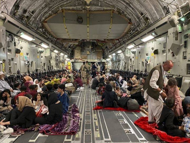 Afghan people sit inside a US military aircraft to leave Afghanistan, at the military airport in Kabul on August 19, 2021 after Taliban's takeover of Afghanistan | Photo: AFP
