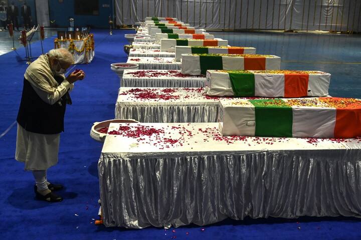India's Prime Minister Narendra Modi, pays his tribute in front of the coffins containing the mortal remains of Chief of Defence Staff Gen Bipin Rawat and other 12 victims who lost their lives in a helicopter crash a day earlier, during a tribute ceremony at Palam Air Force station in New Delhi on December 9, 2021. (Image: AFP)