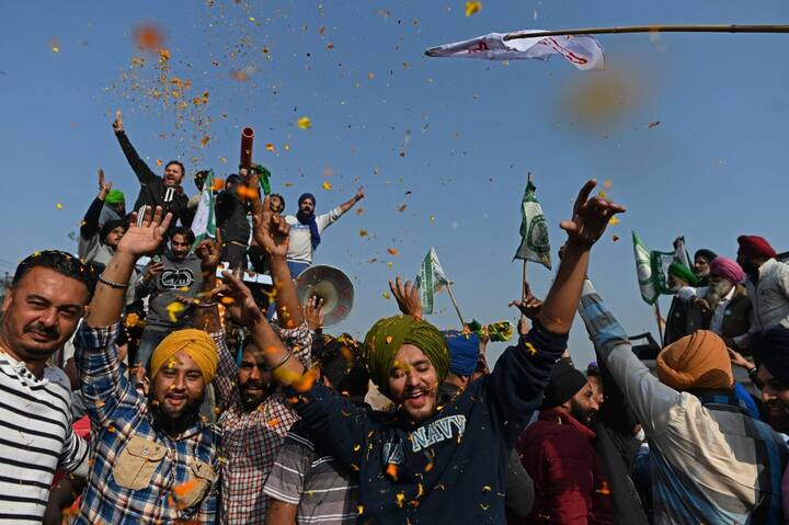 Farmers cheer as they leave the protest site at the Delhi-Haryana state border in Singhu on December 11, 2021, as farmers headed home from the Delhi outskirts following a year-long protest against the government's agriculture policies. (Image: AFP)