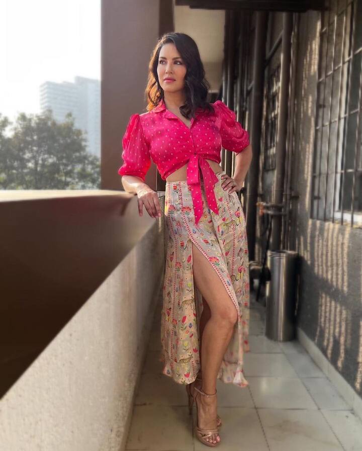 इस फोटो में सनी लियोानी पिंक क्रॉप टॉप और थाई स्लिट स्कर्ट पहने पोज़ देती दिख रही हैं.