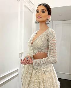 Tara Sutaria Photos: डीप नेक ब्लाउज, व्हाइट लहंगा पहन हुस्न की परी लगीं तारा सुतारिया, माथे की बिंदी ने भी उड़ाई फैंस की नींद