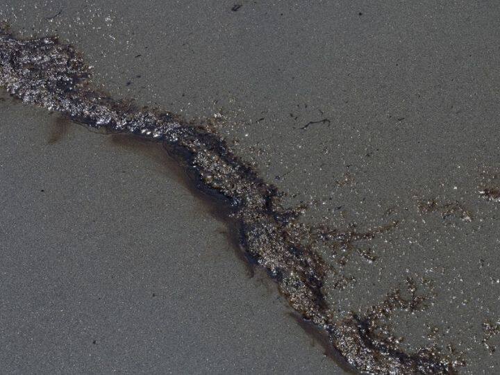 Oil wash ashore at a beach in the Peruvian province of Callao on January 17, 2022, after a spill that occurred during the unloading process of the Italian-flagged tanker, 'Mare Doricum', at La Pampilla refinery, caused by the abnormal waves recorded after the volcanic eruption in Tonga | Photo: AFP