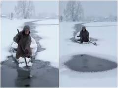 Watch: भारी ठंड के कारण जम गई कश्मीर की फेमस डल झील, बर्फ तोड़ कर रास्ता बनाता दिखा शख्स