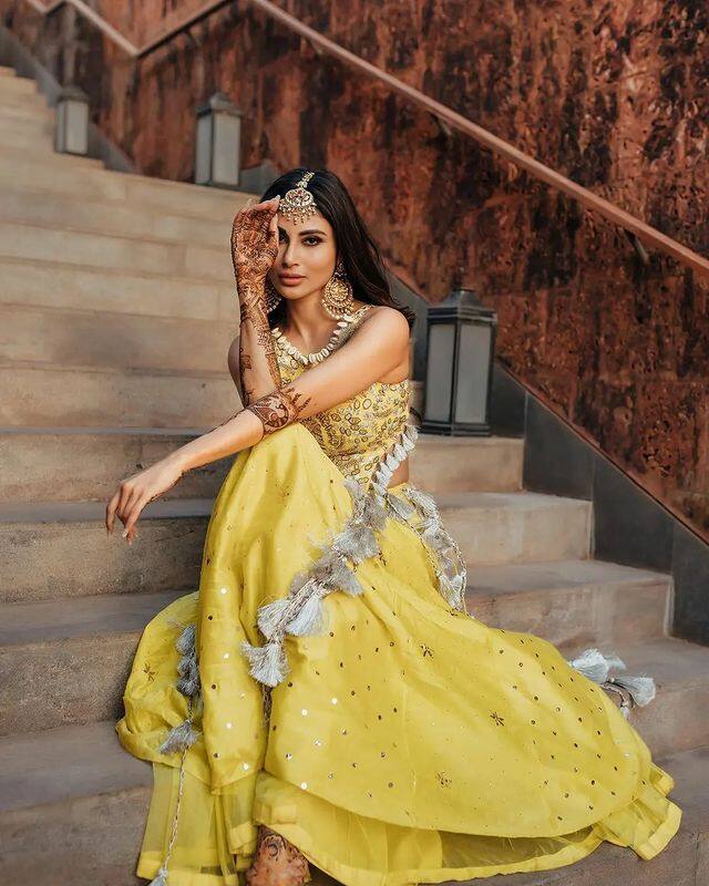 'नागिन' फेम अभिनेत्री मौनी रॉयच्या (Mouni Roy) हाताला सूरज नांबियारच्या नावाची मेहंदी लागली आहे. 27 जानेवारीला मौनी सूरज नांबियारसोबत लग्नबंधनात अडकणार आहे. (all photo credit: weddingplz/ig)