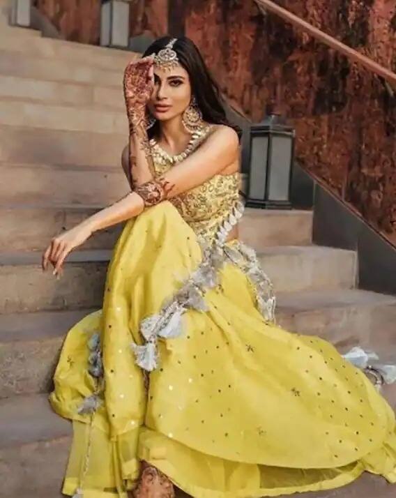 दुसरे फंक्शन मौनी रॉयच्या मेहेंदी सेरेमनीचे होते. यामध्ये तिने पिवळ्या रंगाचा ड्रेस कॅरी केला आहे. या ड्रेसला टॅसल वर्क केले होते. मौनीने या ड्रेसबरोबर मांग टिका आणि सुंदर कानातले घातले होते.