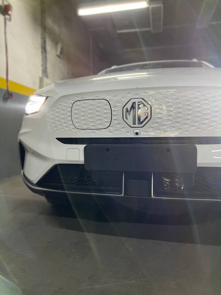 नई MG ZS EV में फ्रंट-कवर ग्रिल, और चार्जिंग सॉकेट - जो अब MG लोगो के लेफ्ट साइड में दिया गया है. फीचर्स के मामले में इसमें सनरूफ और नए 17-इंच के फ्रेश डिजाइन वाले अलॉय व्हील दिए गए हैं.