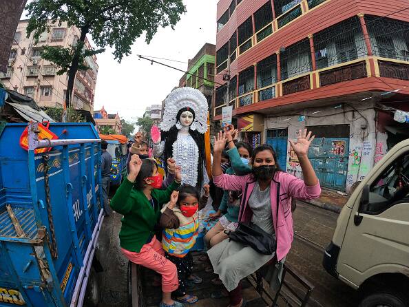 Girls sit on a rickshaw van taking an idol to her home for worshiping purposes. Basant Panchami or Vasant Panchami is a Hindu festival that celebrates the coming of spring in India. (via Getty Images)