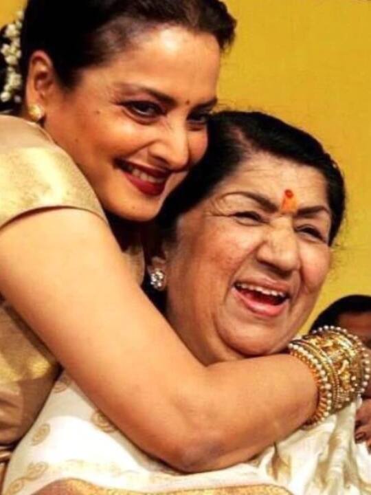 दिग्गज अभिनेत्री रेखा (Rekha) भी इस तस्वीर में लता मंगेशकर के साथ बेहद प्यार और सम्मान से पेश आती दिख रही हैं. तस्वीर में लता जी की दिल से निकली मुस्कान दोनों का आपसी रिश्ता बताने के लिए काफी है.