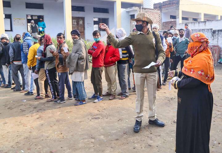 A seecurity personnel assisting a voter. 11 districts of western Uttar Pradesh are undergoing polls today | Courtesy: PTI