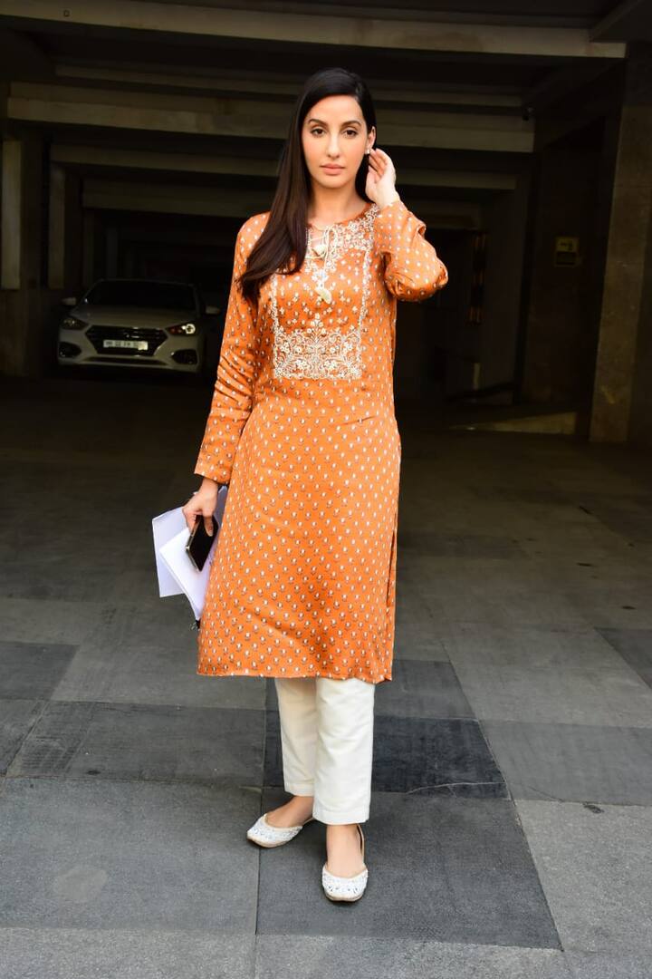 She is wearing an orange full-sleeved printed kurta with white straight-legged pants. To complete her look, she wore a pair of white juttis.