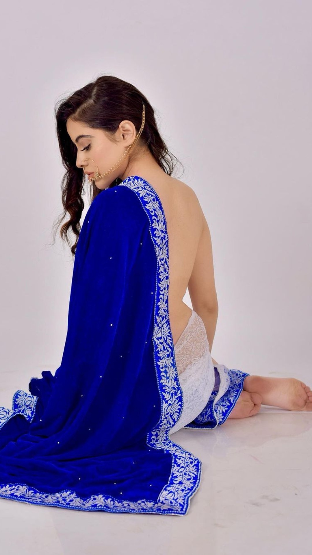 Lady in red saree with long hair in backpose sitting near the banks of  river and praying to Moon