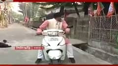 Municipal Election: স্কুটার চালিয়ে বিভিন্ন জায়গায় ঘুরছেন শিলিগুড়ির ২৪ নম্বর ওয়ার্ডের বিজেপি প্রার্থী শঙ্কর ঘোষ। Bangla News