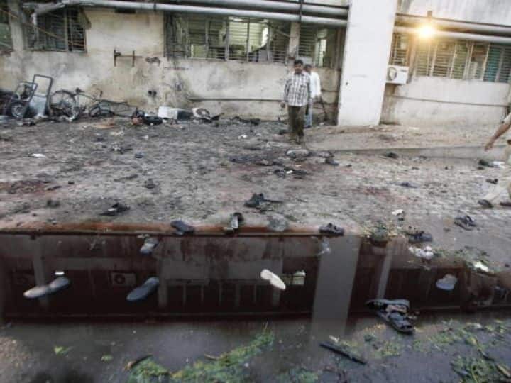 The blasts were similar to the Bangalore blasts that occurred in Karnataka the day before. In this image, a policeman (R) walks past a bomb blast site outside a hospital in Ahmedabad on July 27, 2008. | Photo: Getty Images