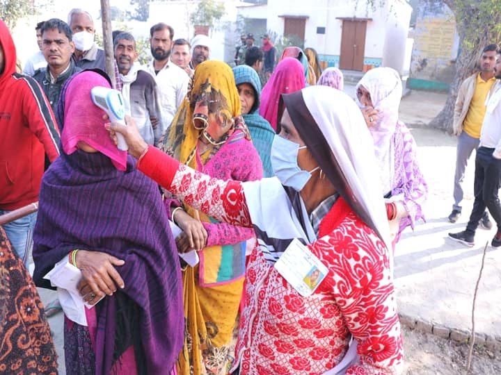 People undergo thermal screening as they wait in a queue to cast their votes at a polling booth, during the third phase of Uttar Pradesh Assembly elections, in Hathras, Sunday, Feb. 20, 2022. (PTI Photo)