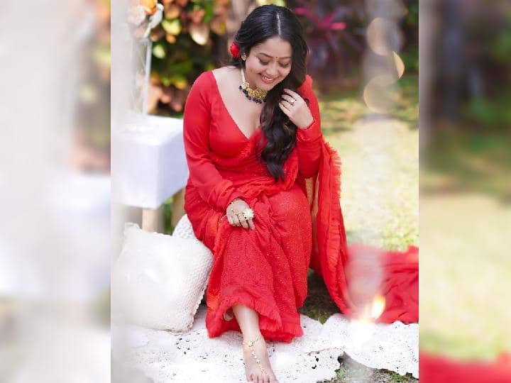 फोटोंमध्ये, नेहा कक्कर सैल केस, स्मोकी मेकअप, कपाळावर एक छोटी बिंदी आणि केसांमध्ये लाल गुलाबासह लूक पूर्ण केलेला दिसत आहे.