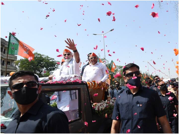 PM Narendra Modi waves at people during a roadshow in Dahegam in Gandhinagar PM Modi Road Show: गुजरात दौरे के दूसरे दिन PM मोदी का गांधीनगर में रोड शो, राष्ट्रीय रक्षा यूनिवर्सिटी भवन का किया उद्घाटन