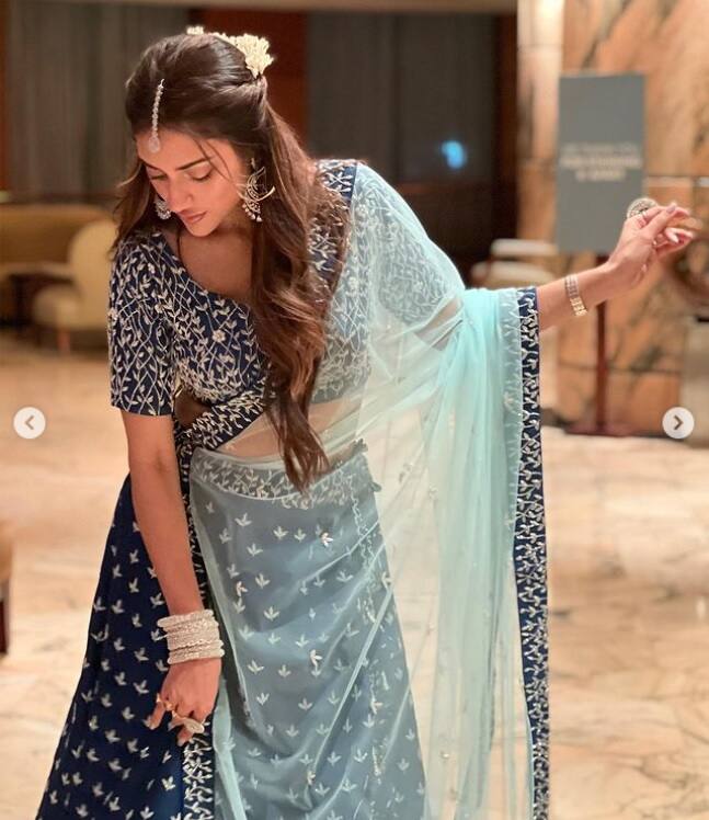 নীল লেহঙ্গায় অপরূপা টলিউড অভিনেত্রী নুসরত জাহান। খোলা চুলে ফুলের সাজ। সোশ্যাল মিডিয়ায় বাংলাদেশের বিয়েবাড়ি থেকে ছবি ভাগ করে নিলেন নুসরত জাহান (Nusrat Jahan)।