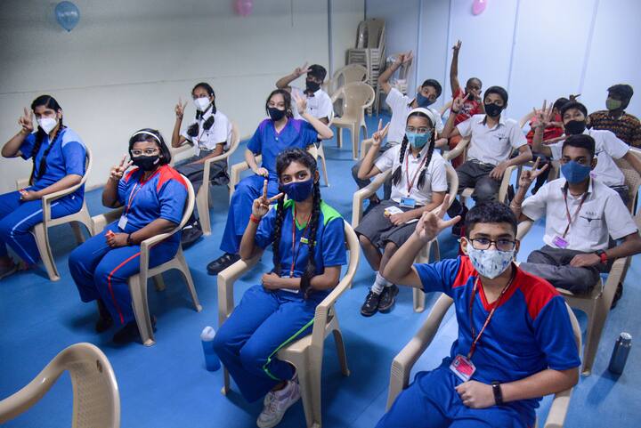 Students pose for photos while waiting to receive a dose of Covid-19 vaccine in Thane. In Maharashtra, the government has directed officials to hold 10 dedicated sessions in each district as the state targets to vaccinate 39 lakh children under this inoculation drive. (Image: PTI)