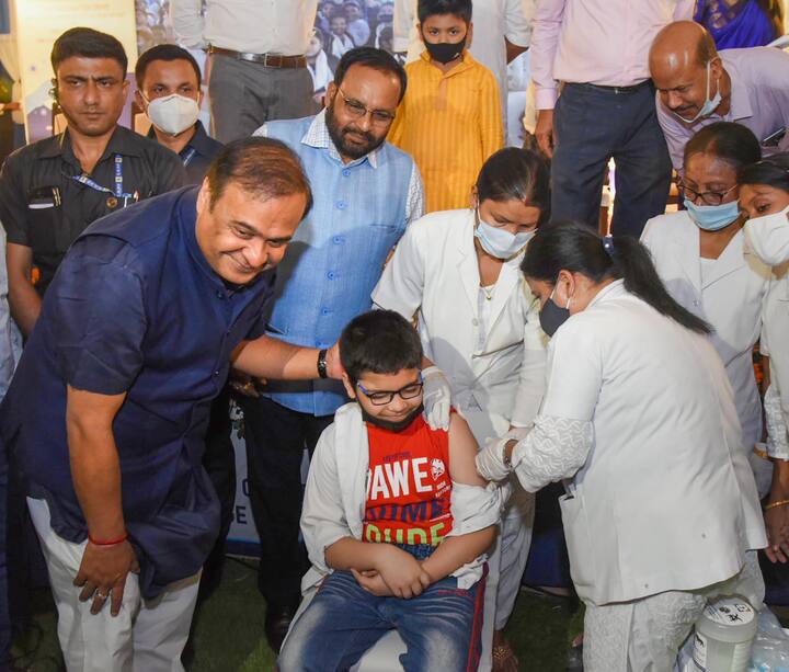 A healthcare worker administers a dose of the Covid-19 preventive vaccine to a student in the age group of 12 to 14 years in the presence of Assam CM Himanta Biswa Sarma, at a vaccination centre, in Guwahati. Vaccination for children in the age group of 12 to 14 years began on Wednesday. (Image: PTI)