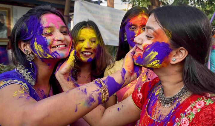 Young women smear colour on each others faces, in celebration of the festival of Holi, in Kolkata. The West Bengal government has given some relaxation in Covid curb on the occassion of Holi. (Image: PTI)