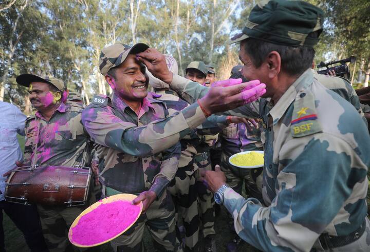 Border Security Force (BSF) soldiers play with colours and dance to celebrate the festival of Holi at the India-Pakistan border of Golpattan, in Jammu. (Image: PTI)