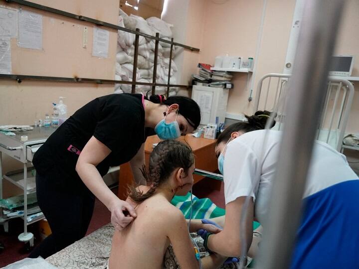 Nurses tend to Milena, a 13-year-old girl who was hit by a bullet as she was evacuating from Mariupol with her family, in a room protected by sandbags at the Zaporizhzhia Regional Clinical Children's Hospital. (Photo: AFP)