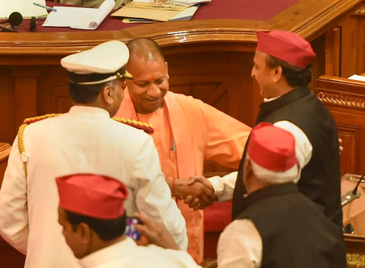 यूपी के मुख्यमंत्री योगी आदित्यनाथ सोमवार को विधानसभा में सदन के नेता के रूप में शपथ ली. साथ ही नेता प्रतिपक्ष अखिलेश यादव ने विधानसभा में सदन के विधायक पद की शपथ ली. विधानसभा में ही दोनों दिग्गजों ने एक दूसरे का गर्मजोशी से स्वागत किया. इस तस्वीर में योगी आदित्यनाथ विधानसभा में आगे की ओर बढ़ते दिखाई दे रहे हैं. वहीं, अखिलेश यादव भी खड़े नजर आ रहे हैं. अखिलेश आगे बढ़कर योगी की ओर हाथ बढ़ाते दिख रहे हैं और योगी भी उनसे हाथ मिला रहे हैं और दूसरे हाथ से उनके कंधे को थपथपाते हैं. यूपी के सियासी गलियारे में इस तस्वीर की खूब चर्चा हो रही है. (फोटो- PTI)