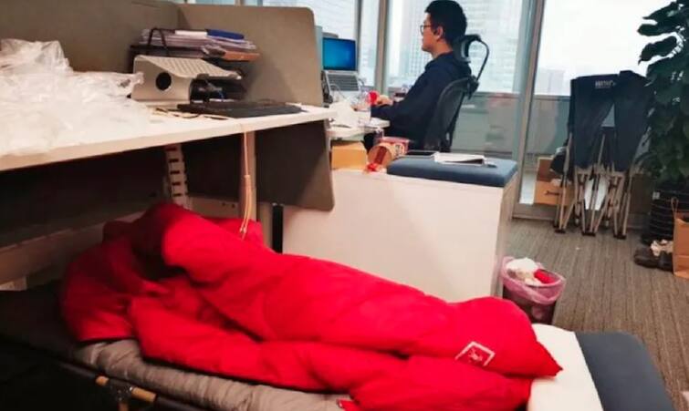 In China's Shanghai, Bankers And Traders Sleep In Offices To Beat Covid Lockdown આ દેશમાં ઓફિસમાં કેમ સૂઇ રહ્યા છે કર્મચારી? એક રાત કામ કરવાના મળી રહ્યા છે 23 હજાર રૂપિયા