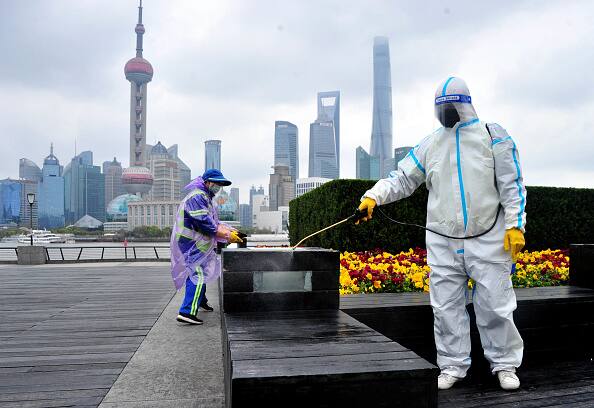 Sanitation workers wearing personal protective equipment (PPE) conduct disinfection work at The Bund in Shanghai, China. (Source: Getty Images)