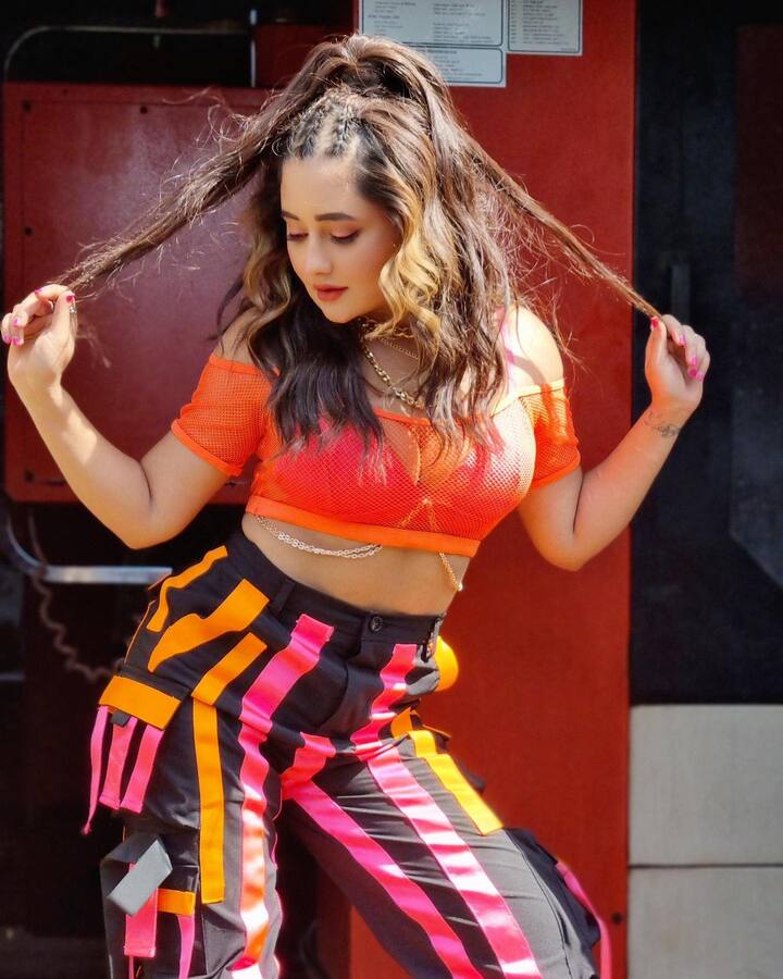 She wore a neon orange crop top combined with colourblocked pants in the post. Lovely gold chains and a magnificent hairstyle were the finishing touches on the actress's stunning look.