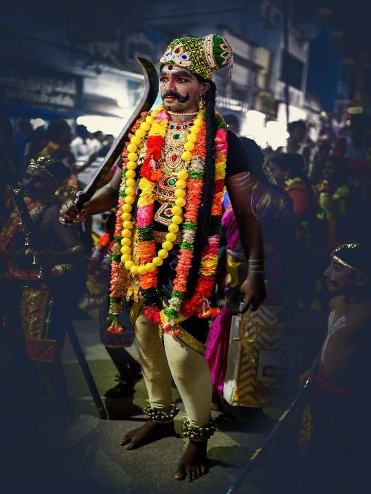 காவல் தெய்வம் கருப்பசாமி வேடத்தில் இளைஞர் கம்பீரமாக காட்சியளிக்கும் புகைப்படம்.