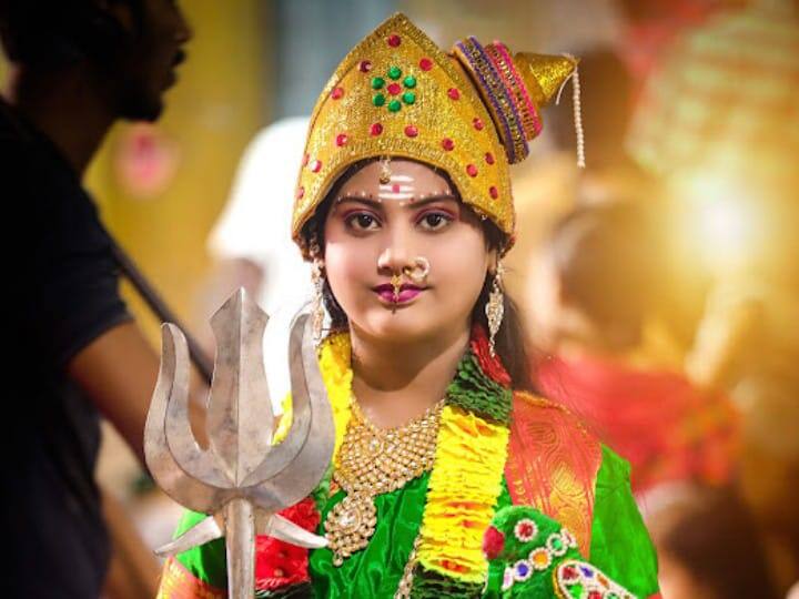 முழு நிலவைப் போல சிறுமி மீனாட்சி வேடமணிந்து அருள் பாலிக்கும் காட்சி.