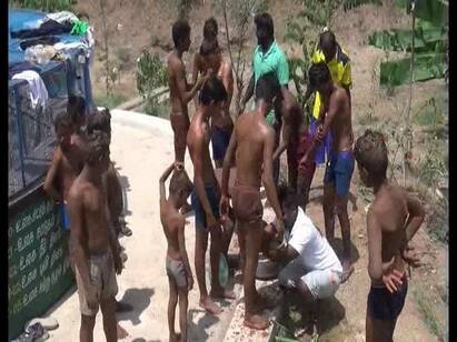 Dharmapuri Students takes termite mud bath தருமபுரி அருகே கரையான் புற்று மண்ணை உடலில் பூசி மண் குளியலில் ஈடுபடும் மாணவர்கள்