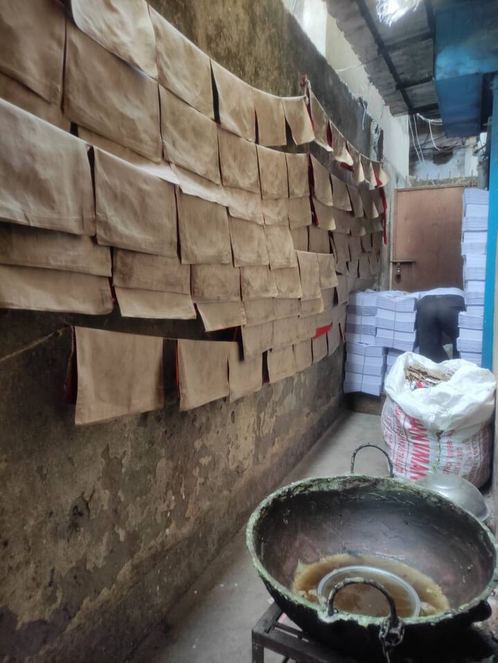 To make a haal khata, first the red cloth material is cut and glued to fims of canvas of the same size. These are then hung in the ropes outside to dry. The books are then stitched using a thread and a twine is used to tie the books. (Photo: Abhishek De)
