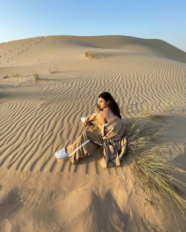 रेगिस्तान की रेत पर बैठी मौनी रॉय प्रकृति के हर एक मौसम हर एक नजारे की झलक दिखा रही हैं.