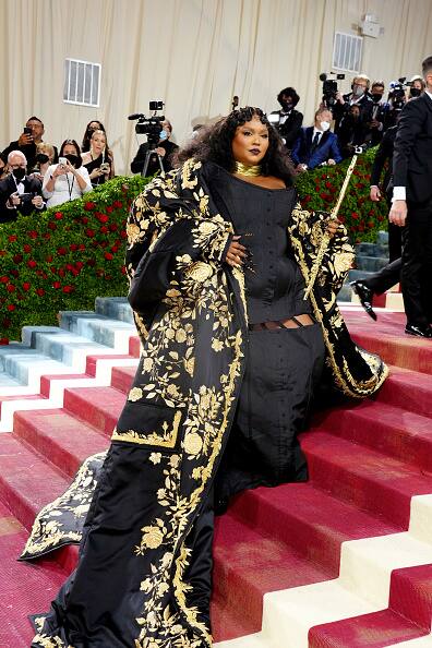 Three-time Grammy winner Lizzo wore a black Thom Browne corset gown.Lizzo turned up with her all gold signature flute and played on the red carpet for reporters.